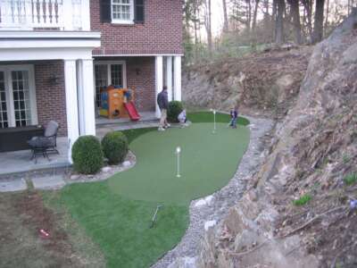 Finished custom outdoor golf putting green after panel and turf installation